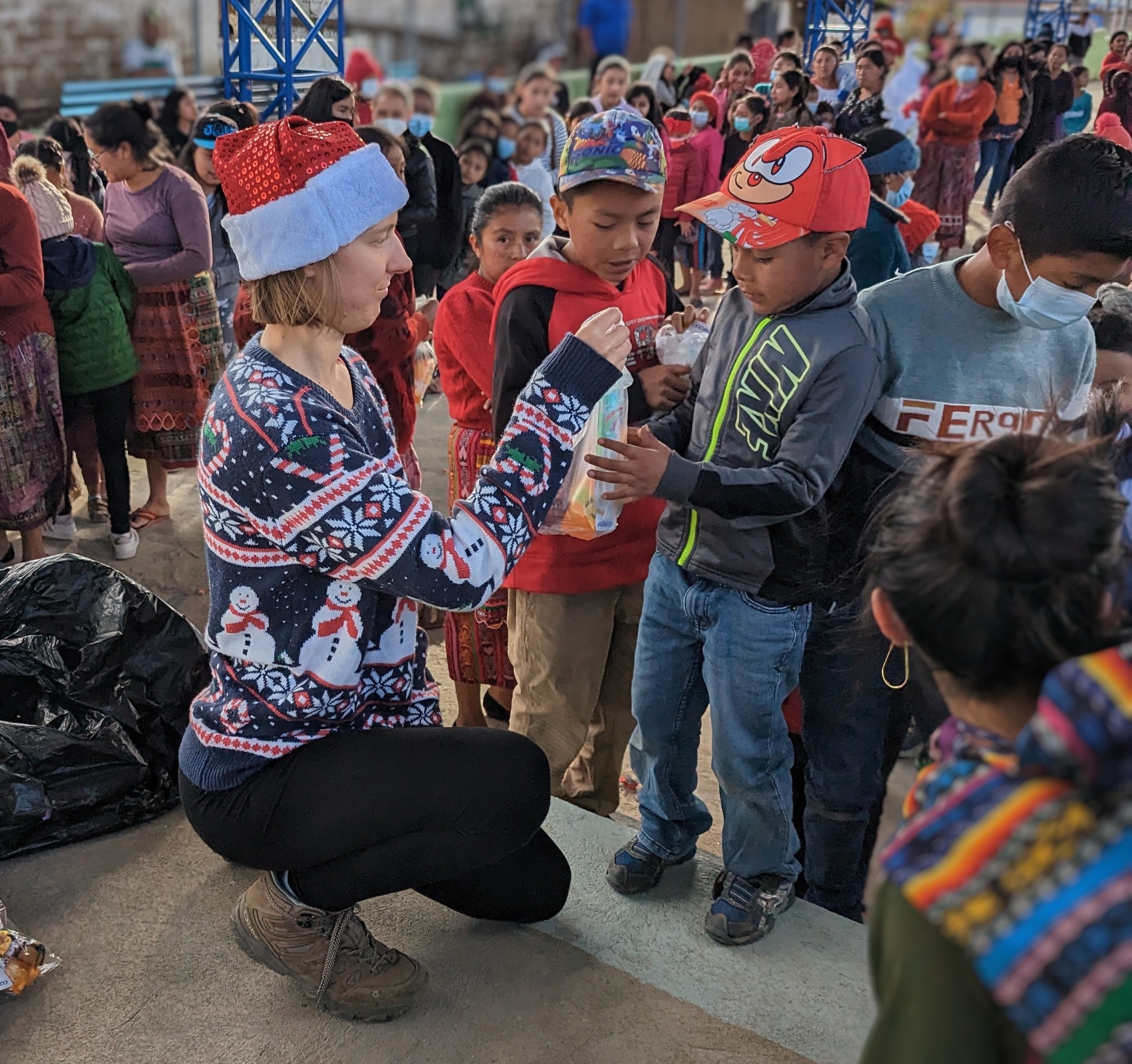 Random Acts Staff Madison Petro hands a goodie bag to one of many small children