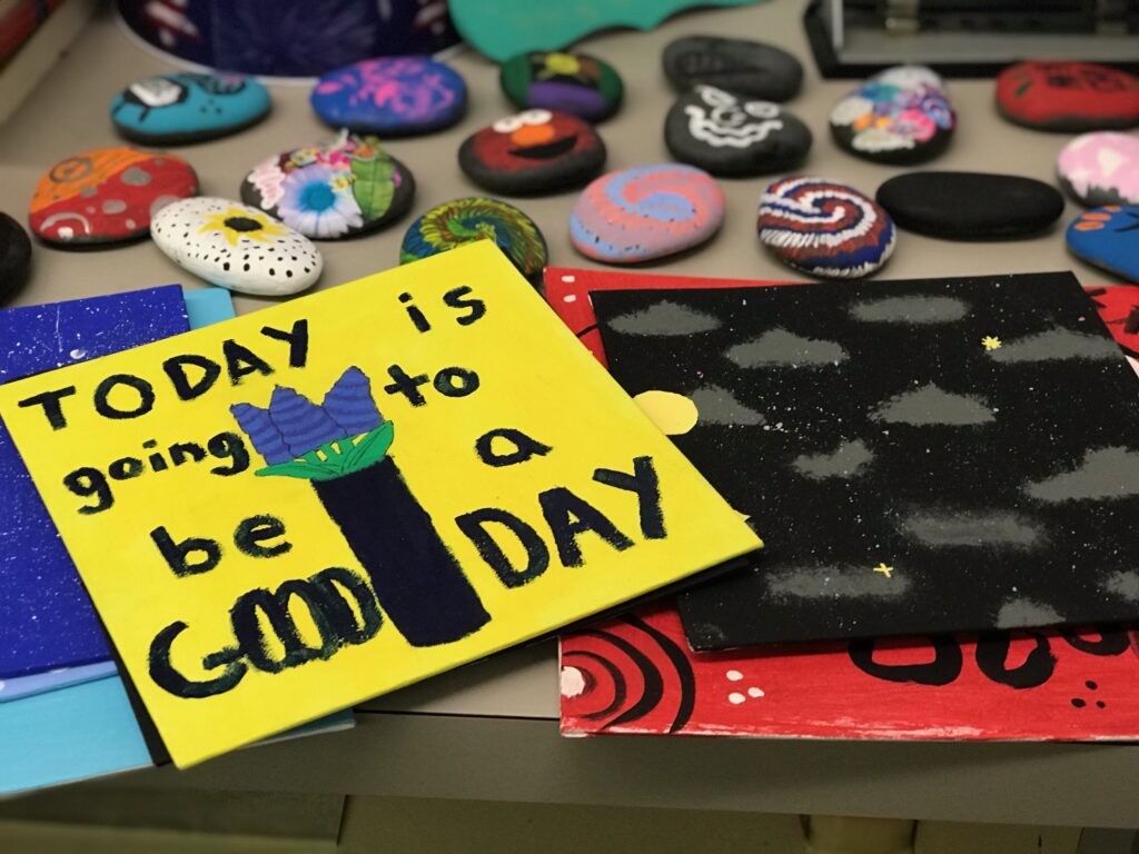 Colorful painted rocks with a small painted sign that says, "Today is going to be a good day"