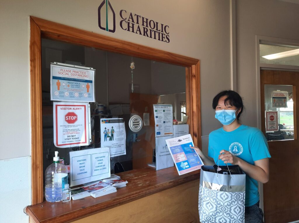 Rebecca delivering a bagful of period packs to the front desk of a shelter